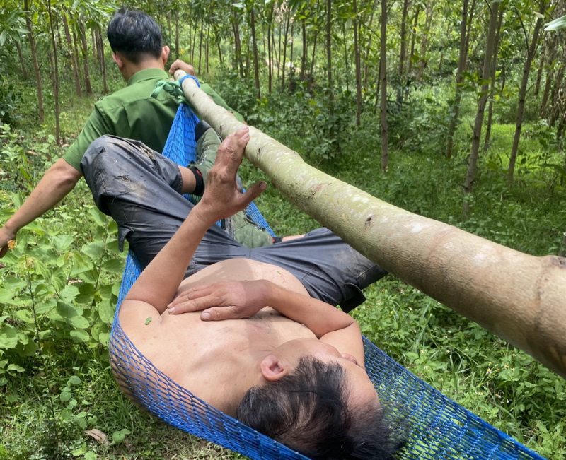 Các chiến sĩ Công an xã mắc võng đưa nạn nhân bị ong đốt xuống núi để cấp cứu 